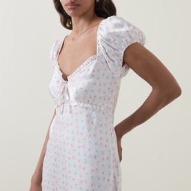 Model wearing LOVESHACKFANCY Ivory Rose floral dress with sweetheart neckline, ruched bust tie detail and short puff sleeves.
