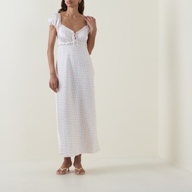 Model wearing LOVESHACKFANCY Ivory Rose midi dress with flutter sleeves, sweetheart neckline, and floral pattern, styled with nude flat sandals.