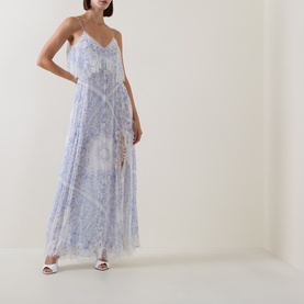 Model wearing LOVESHACKFANCY Dress in Indigo Shores, a floaty silk maxi with floral print, V-neckline and thin straps, styled with white heeled