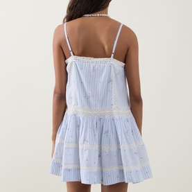 Model wearing LOVESHACKFANCY Sky Mist cotton mini dress, back view, spaghetti straps, lace trim detailing and tiered skirt