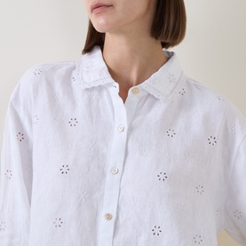 Model wearing LOVESHACKFANCY Optic White linen shirt with broderie anglaise floral cutwork detail and button-front placket.