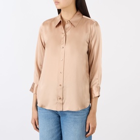 Model wearing L'Agence soft nude 100% silk blouse with pointed collar, button front, and three-quarter sleeves, styled with blue jeans