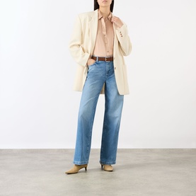 Model wearing LAgence Soft Nude silk blouse with cream blazer, light blue wide-leg jeans, and tan heeled mules with brown belt.