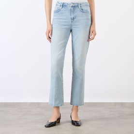 Model wearing L'Agence Crop Boot jeans in light blue denim, styled with black square-toe mule heels.