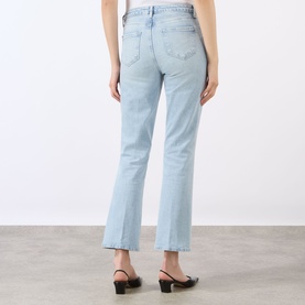 Model wearing LAgence Crop Boot jeans in light blue denim, rear view, styled with black mule heels