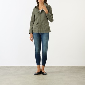 Model wearing LAgence Smokey Olive cotton-linen jacket with front pockets, styled with blue skinny jeans and black flats.