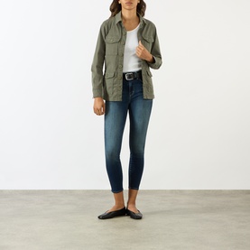 Model wearing LAgence Smokey Olive cotton-linen jacket with chest pockets, styled with white tee, dark wash jeans and black flats.