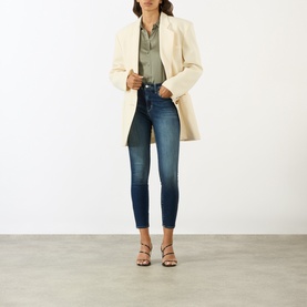 Model wearing LAgence dark blue skinny jeans, styled with a cream blazer, khaki shirt and strappy sandals