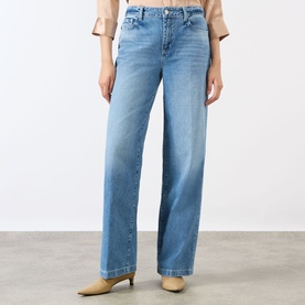 Model wearing LAgence Light Blue Wide Leg Jeans in 100% cotton denim, styled with beige heeled mules and a blush top.