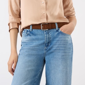 Model wearing LAgence light blue wide leg jeans in 100% cotton, styled with a tan shirt and brown leather belt.