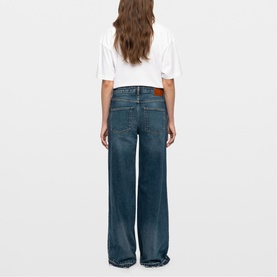Model wearing Zadig blue wide-leg jeans, rear view, styled with a white cropped T-shirt and tan belt