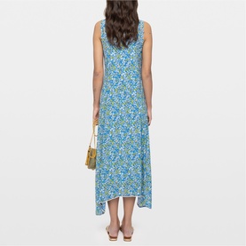 Model wearing Zadig yellow floral midi dress, sleeveless with asymmetric hem, styled with a gold mini bag.
