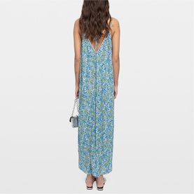 Model wearing Zadig yellow floral maxi dress with V-back, thin straps, styled with a small crossbody bag