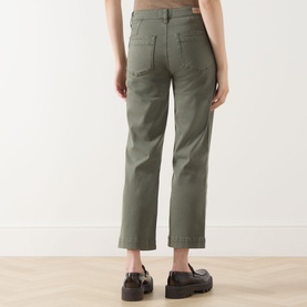 Model wearing Paige Quincy Ankle Straight-Leg Jeans in Vintage Ivy Green, rear view showing patch pockets and brand patch, styled with black loafers.