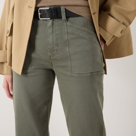 Model wearing Paige Quincy Ankle Straight-Leg Jeans in Vintage Ivy Green, mid-rise straight fit, styled with a black belt and camel jacket.