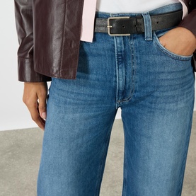Model wearing Paige Arellia Ankle Wide-Leg Jeans in Stoneview, mid-rise with belt loops, styled with a dark leather belt and burgundy jacket.