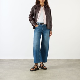 Model wearing Paige Arellia Ankle Wide-Leg Jeans in Stoneview, styled with dark leather jacket, white tee and black sandals.