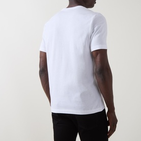 Model wearing Paul Smith Cycle Logo T-Shirt in white cotton, rear view, with black trousers. Round neck, short sleeves, straight hem.
