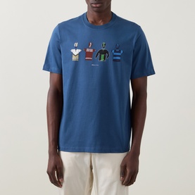 Model wearing Paul Smith Indigo Crew Neck T-Shirt with illustrated clothing graphic print, styled with cream trousers.