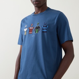 Model wearing Paul Smith Indigo Crew Neck T-shirt with multicoloured abstract cyclist graphic print on chest.