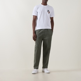 Model wearing Paul Smith white crew neck T-shirt with chest logo, styled with olive green trousers and white trainers.
