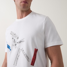 Model wearing Paul Smith Off White Crew Neck T-shirt with abstract graphic print featuring blue and red details, cropped chest view