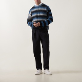 Model wearing Paul Smith Black/Blue striped wool crew neck jumper, styled with black tailored trousers and white trainers.