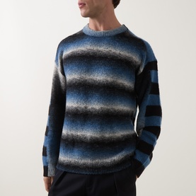 Model wearing Paul Smith Black/Blue wool blend crew neck jumper with gradient stripe pattern, styled with dark trousers.