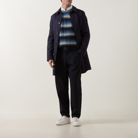 Model wearing Paul Smith Black/Blue wool crew neck jumper, styled with navy overcoat, black trousers and white trainers.