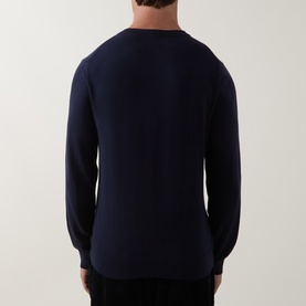 Model wearing Paul Smith navy crew neck cotton jumper, rear view showing clean back seam and ribbed cuffs and hem