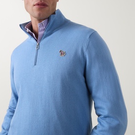 Model wearing Paul Smith Light Blue cotton half-zip jumper with zebra logo patch, styled over a pink check shirt.