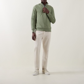 Model wearing Paul Smith Half Zip sweatshirt in light grey-green cotton, styled with cream trousers and white trainers.