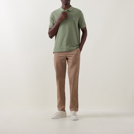 Model wearing Paul Smith polo in light grey/green with beige chinos and white trainers.