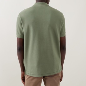 Model wearing Paul Smith polo shirt in light grey/green cotton piqu&eacute;, back view, styled with stone chinos.