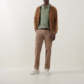 Model wearing Paul Smith light green cotton polo, styled with tan suede jacket, taupe chinos and white trainers.