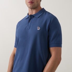 Model wearing Paul Smith Indigo polo shirt with short sleeves, ribbed collar, three-button placket and embroidered zebra logo badge on chest