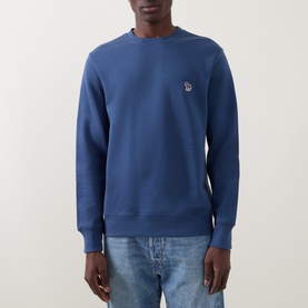 Model wearing Paul Smith Indigo cotton sweatshirt with crew neck and embroidered zebra logo patch, styled with light blue jeans.