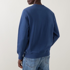 Model wearing Paul Smith indigo cotton sweatshirt, back view, crew neck, styled with light wash jeans.