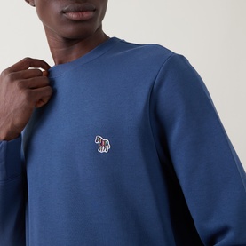 Model wearing Paul Smith indigo cotton sweatshirt with embroidered zebra logo patch at chest, crew neck.