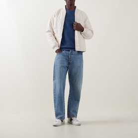 Model wearing Paul Smith Indigo cotton sweatshirt, styled with a cream quilted bomber jacket and light blue relaxed-fit jeans.