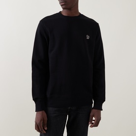 Model wearing Paul Smith black cotton sweatshirt with embroidered zebra logo patch on chest, styled with dark jeans.