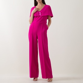 Model wearing Sisters fuchsia jumpsuit with flutter cape sleeves, V-neckline, embellished bodice, and wide-leg trousers.