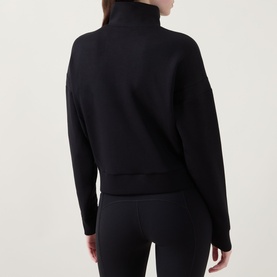 Model wearing Spanx AirEssentials&reg; Track Jacket in Very Black, rear view, mock neck, zip fastening, ribbed cuffs, styled with black leggings.