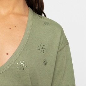 Model wearing Zadig green long-sleeve top with scattered crystal snowflake and pinwheel embellishments on soft cotton fabric