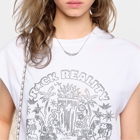 Model wearing Zadig white graphic tee with rhinestone tropical print, styled with a silver chain necklace and white crossbody bag.