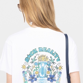 Model wearing Zadig white graphic T-shirt with "Rock Reality" floral rainbow print on back, styled with a dark crossbody bag