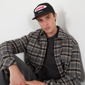 Model with Almost Home Cro&iacute; Patch Logo Baseball Cap in black, flat peak, six panel, worn with grey plaid overshirt