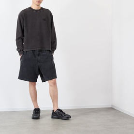 Model wearing Almost Home Porto Black cotton sweatshirt with matching dark shorts and black chunky trainers.
