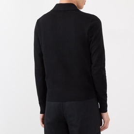 Model wearing black long-sleeve polo-style knit top, back view, styled with matching black trousers