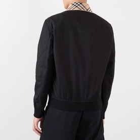 Model wearing Burberry Glenfields Harrington Jacket in black, back view showing signature check collar, ribbed hem and cuffs, with black trousers.